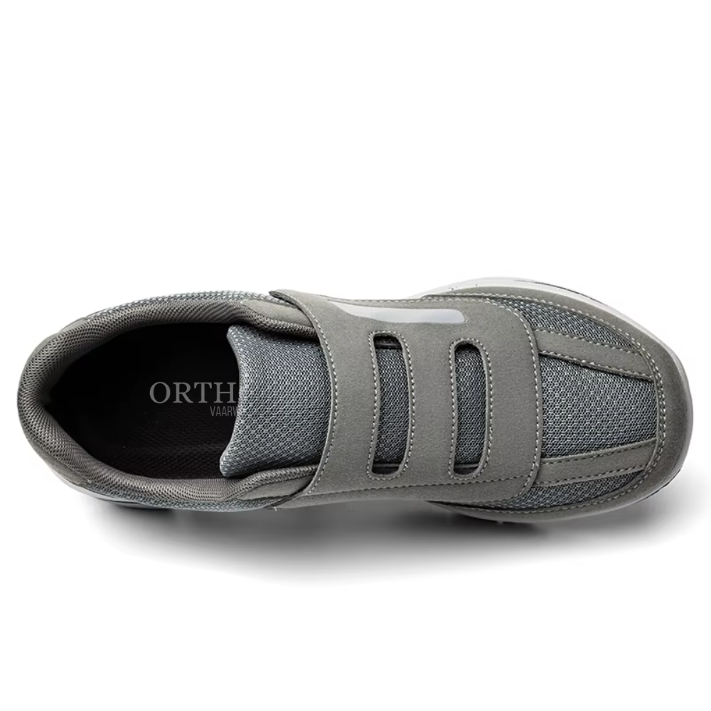 Man's feet resting in supportive, adjustable wide fit orthopedic slip-on shoes for all-day comfort.