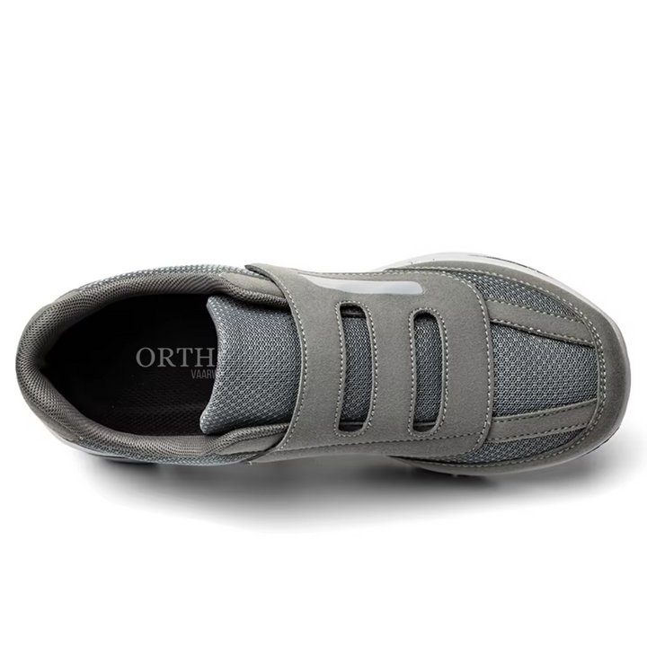 Man's feet resting in supportive, adjustable wide fit orthopedic slip-on shoes for all-day comfort.
