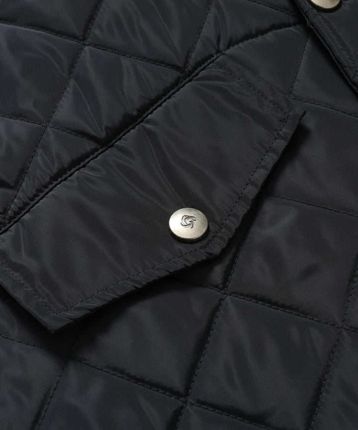Women's longline quilted vest in black, styled with a long-sleeved top, versatile layering piece.