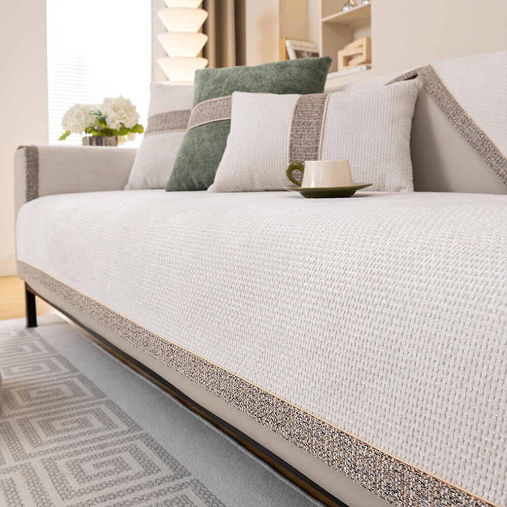 Living room sofa covered with a modern tweed anti-slip furniture protector. Pet-friendly, comfortable & stylish.