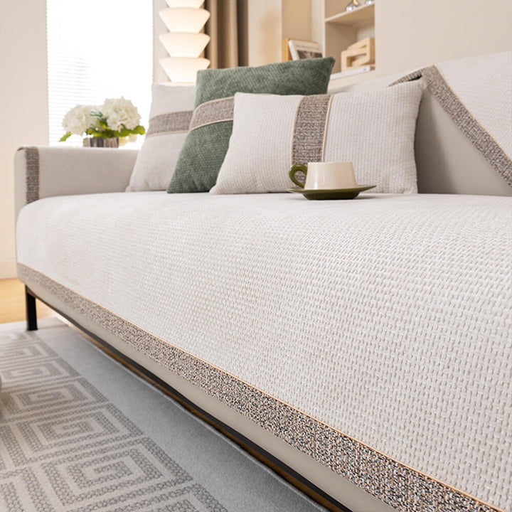 Living room sofa covered with a modern tweed anti-slip furniture protector. Pet-friendly, comfortable & stylish.