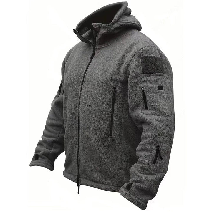Side view of a man wearing a black tactical hooded jacket, ready for outdoor adventure and functional use.