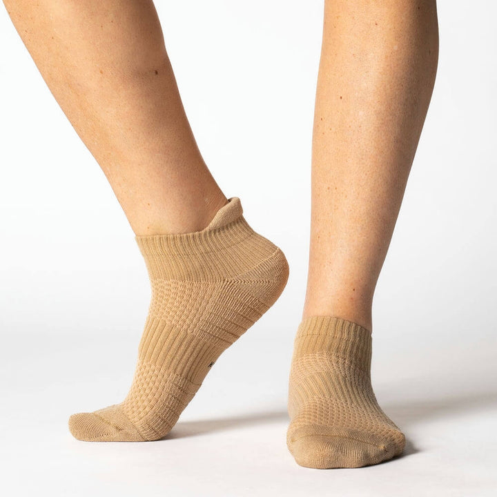 Close-up of a tan ankle compression sock, showcasing its gentle support and comfortable design.