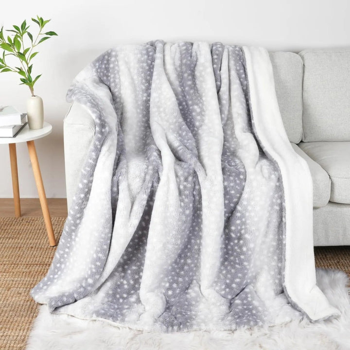 Beautifully folded plush faux fur deer blanket with intricate animal print, ready for bedroom decor.