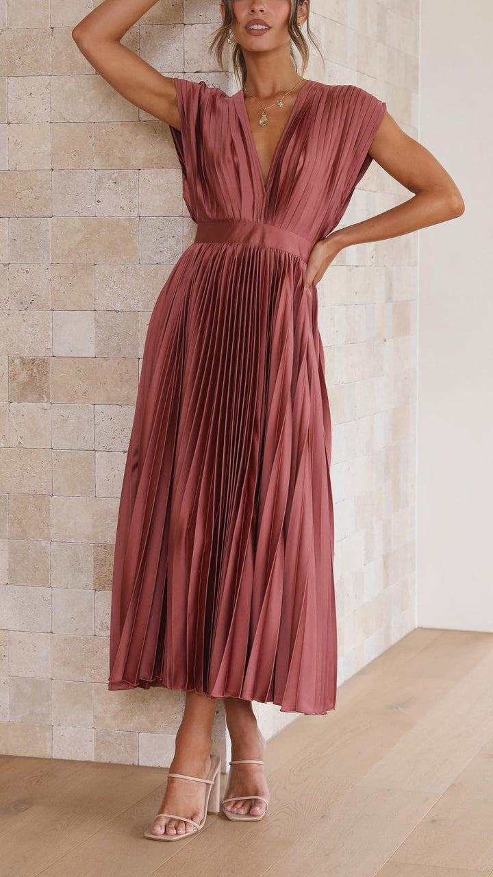 Silk pleated maxi dress with V-neck in rose red, featuring a high waist and elegant flowing pleats for a sophisticated look.