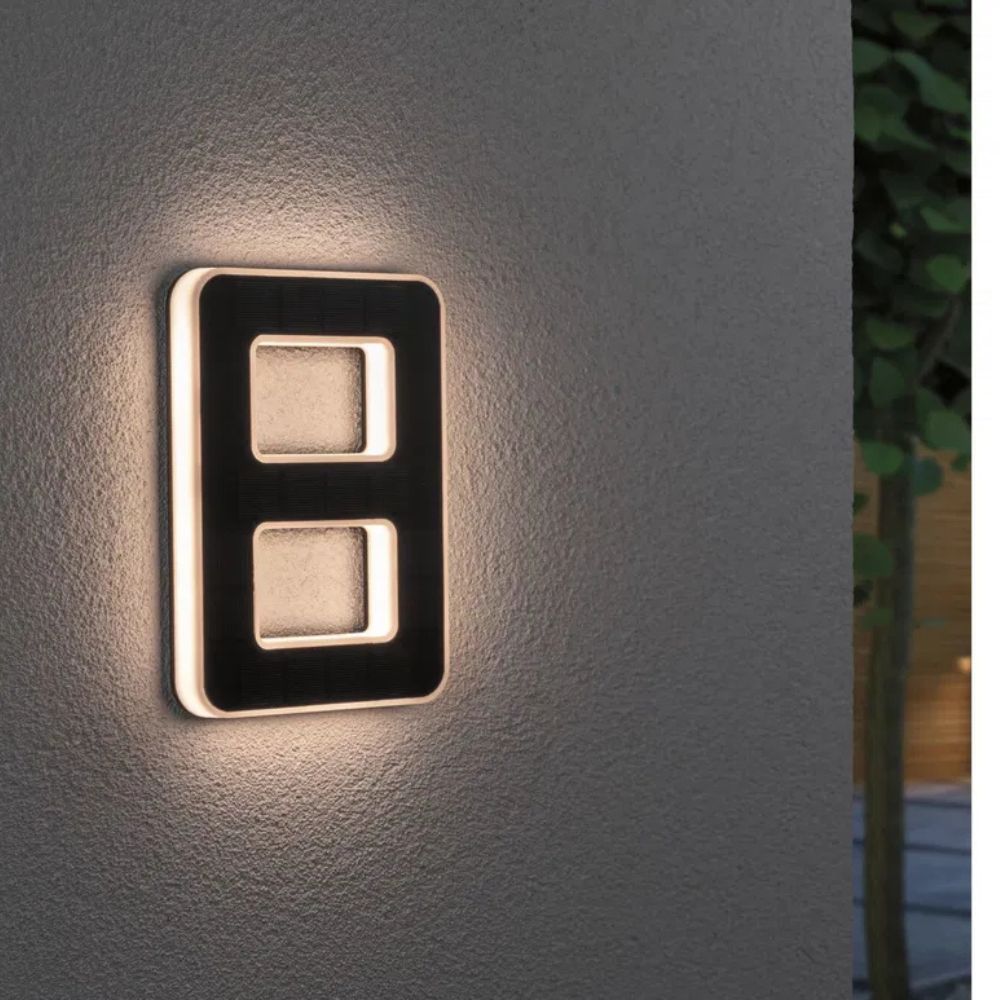 Nighttime view of brightly lit solar house numbers, enhancing safety & curb appeal for visitors.