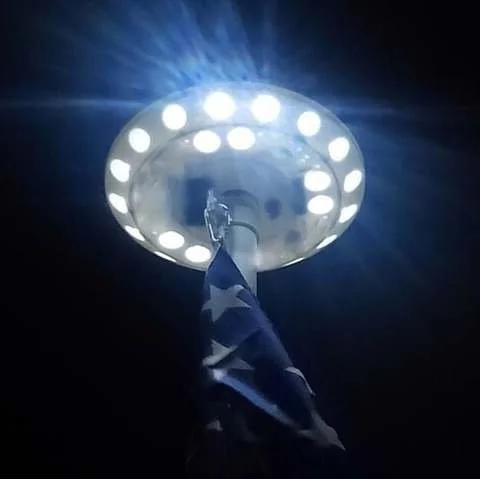 "Solar-powered LED flagpole light with 26 bright LEDs, illuminating flags at night; waterproof and easy to install."