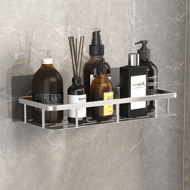 Black metal suction bathroom organizer holding shampoo bottles & shower gels.