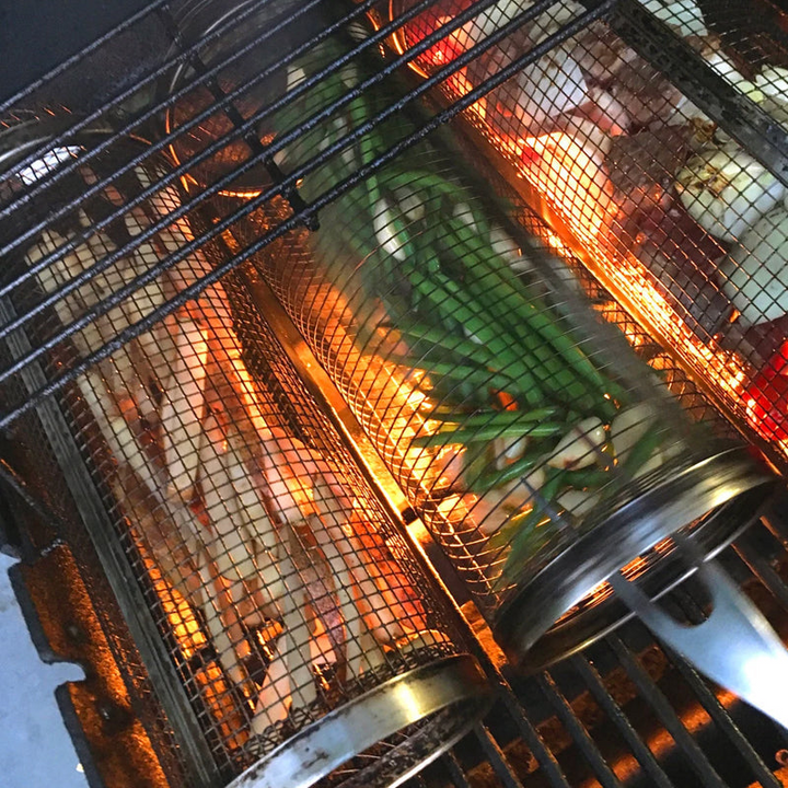 "Stainless steel BBQ grill basket with rotating design for even grilling of veggies and meats, enhancing cooking flavors."