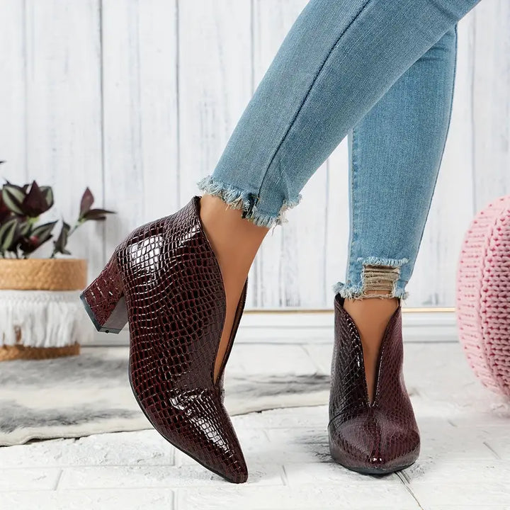 Dynamic shot of women's reptile print ankle boots, highlighting their stylish and chic design.