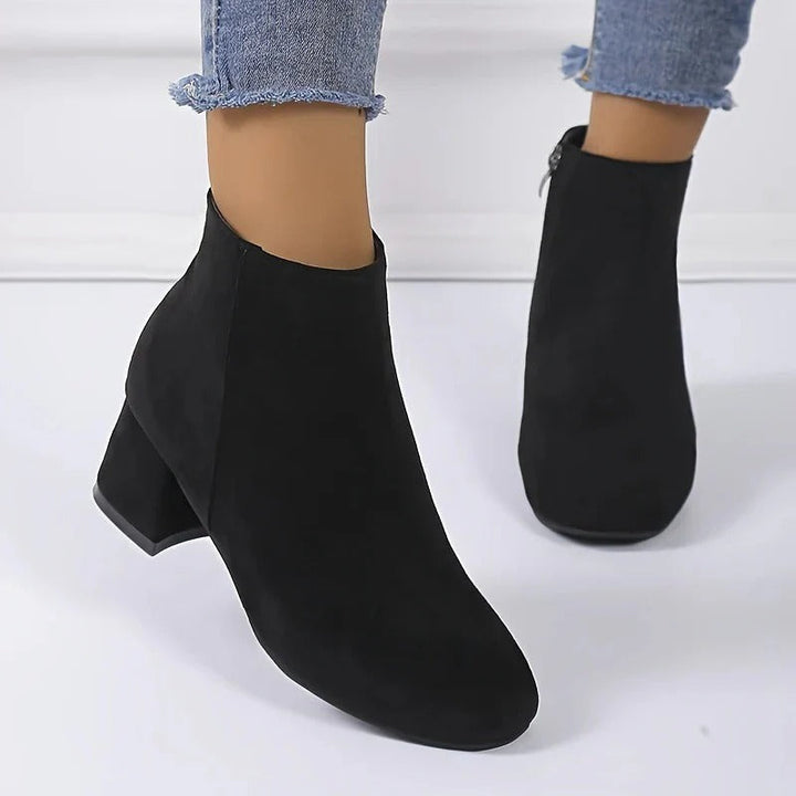 Sleek women's block heel ankle boots with easy-access side zip, offering comfort and style for any occasion.