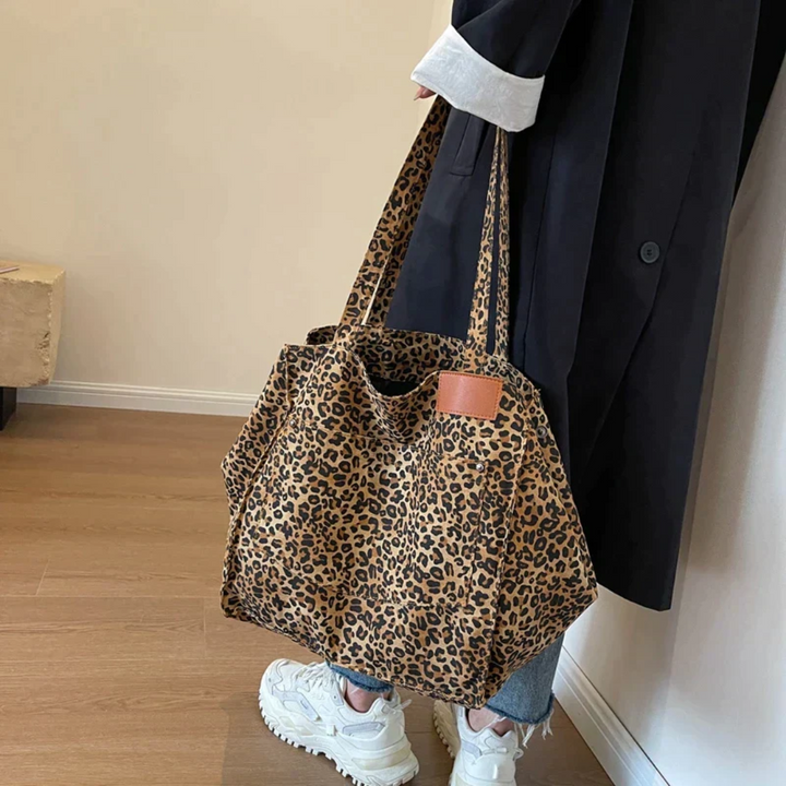 Close-up of women's faux leather leopard print handbag, showing rich texture and elegant animal pattern.