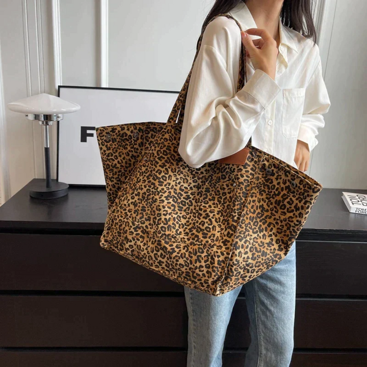 Woman carrying trendy leopard print shoulder bag, a stylish and eye-catching animal print accessory.