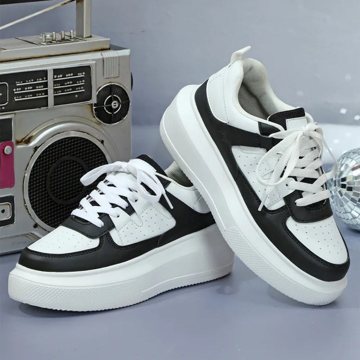 Fashionable women's platform sneakers with stylish perforated design and secure lace-up closure. Trendy footwear.