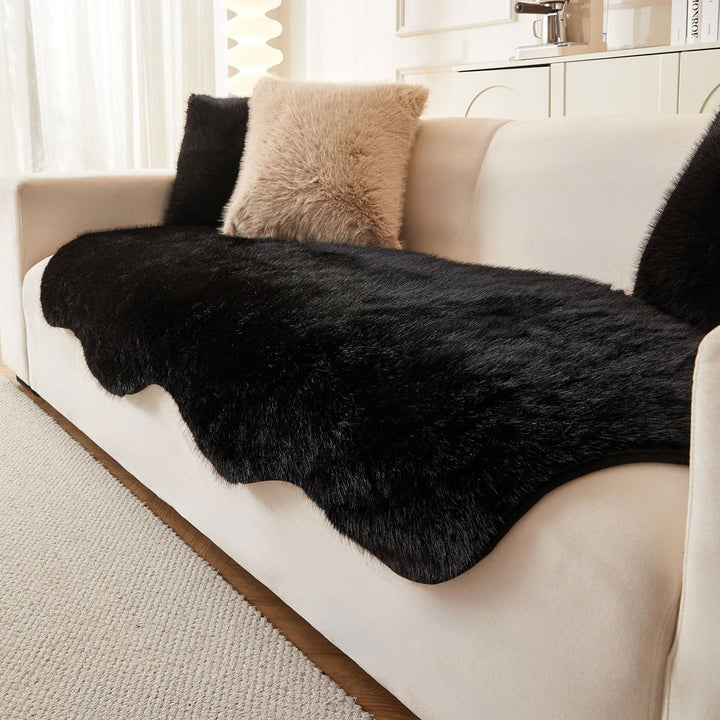 Black ultra-soft sofa cover for living room. Modern Scandinavian style couch protector and fluffy blanket.