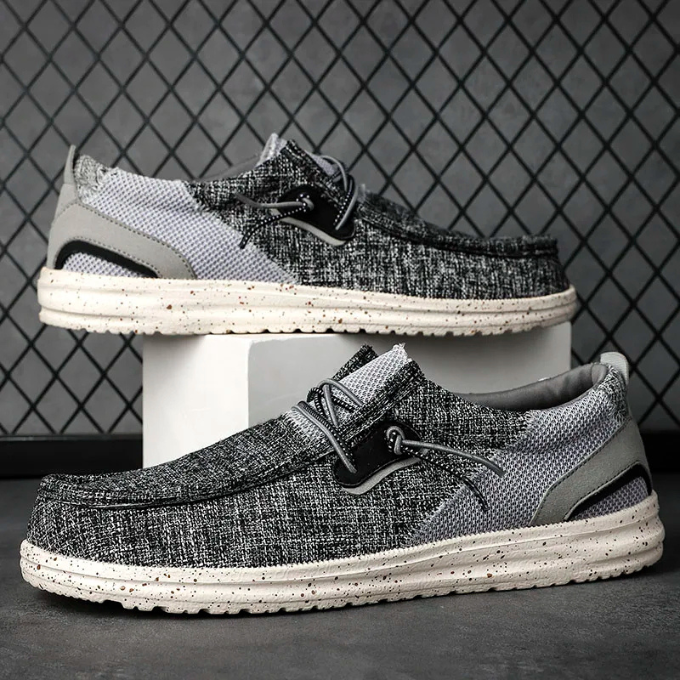 Unisex canvas slip-on shoes on a wooden floor, comfortable and versatile casual footwear.