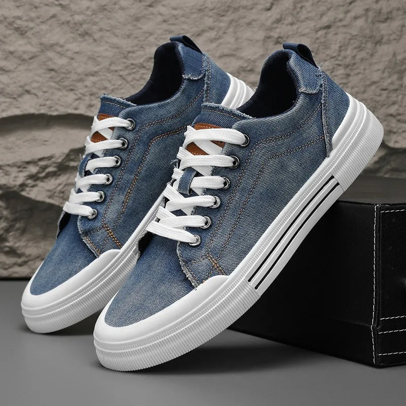 Close-up of a unisex denim low-top sneaker, showcasing the canvas texture and classic design.