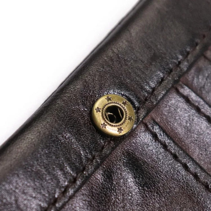Corner detail of a unisex distressed leather wallet, highlight snap & stitching