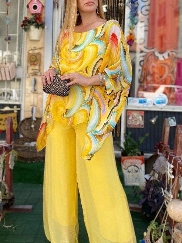 Elegant women's two-piece outfit with a colourful abstract print, featuring a loose batwing top and flowy wide leg pants.