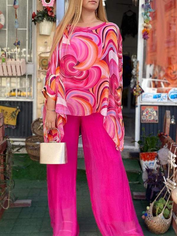 Fashionable women's resort wear set with a unique abstract print batwing top and comfortable wide leg trousers.