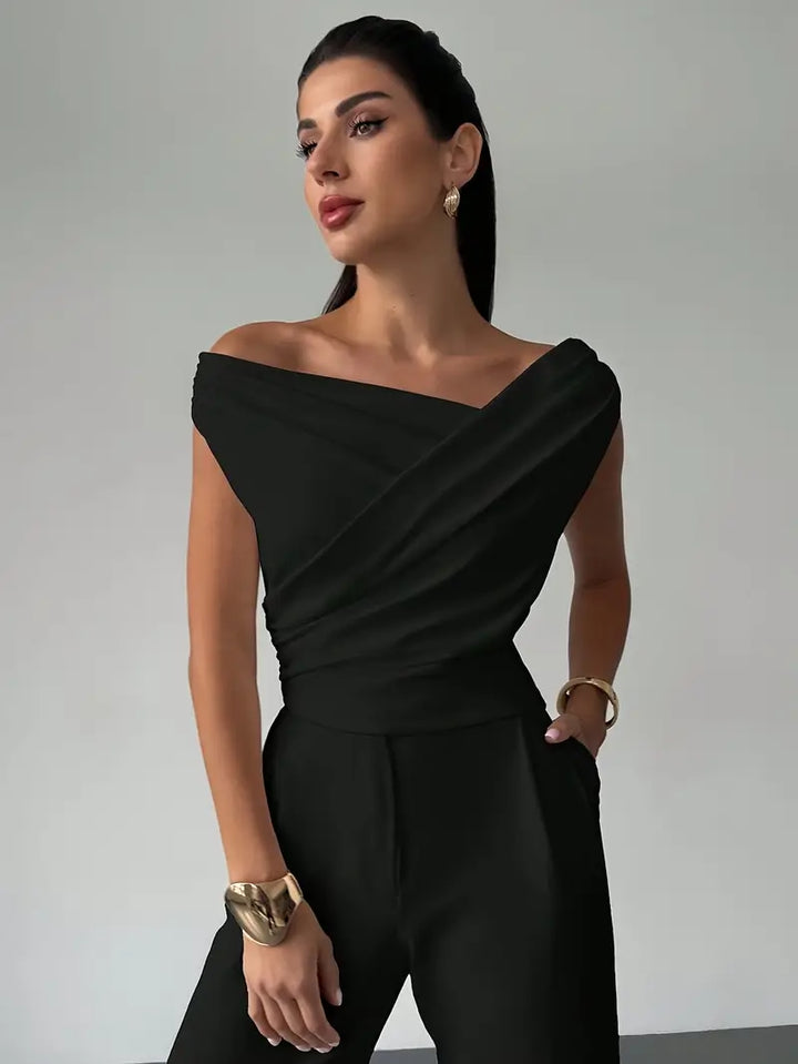 Black sophisticated women's top with draped shoulder detail for versatile fashion.