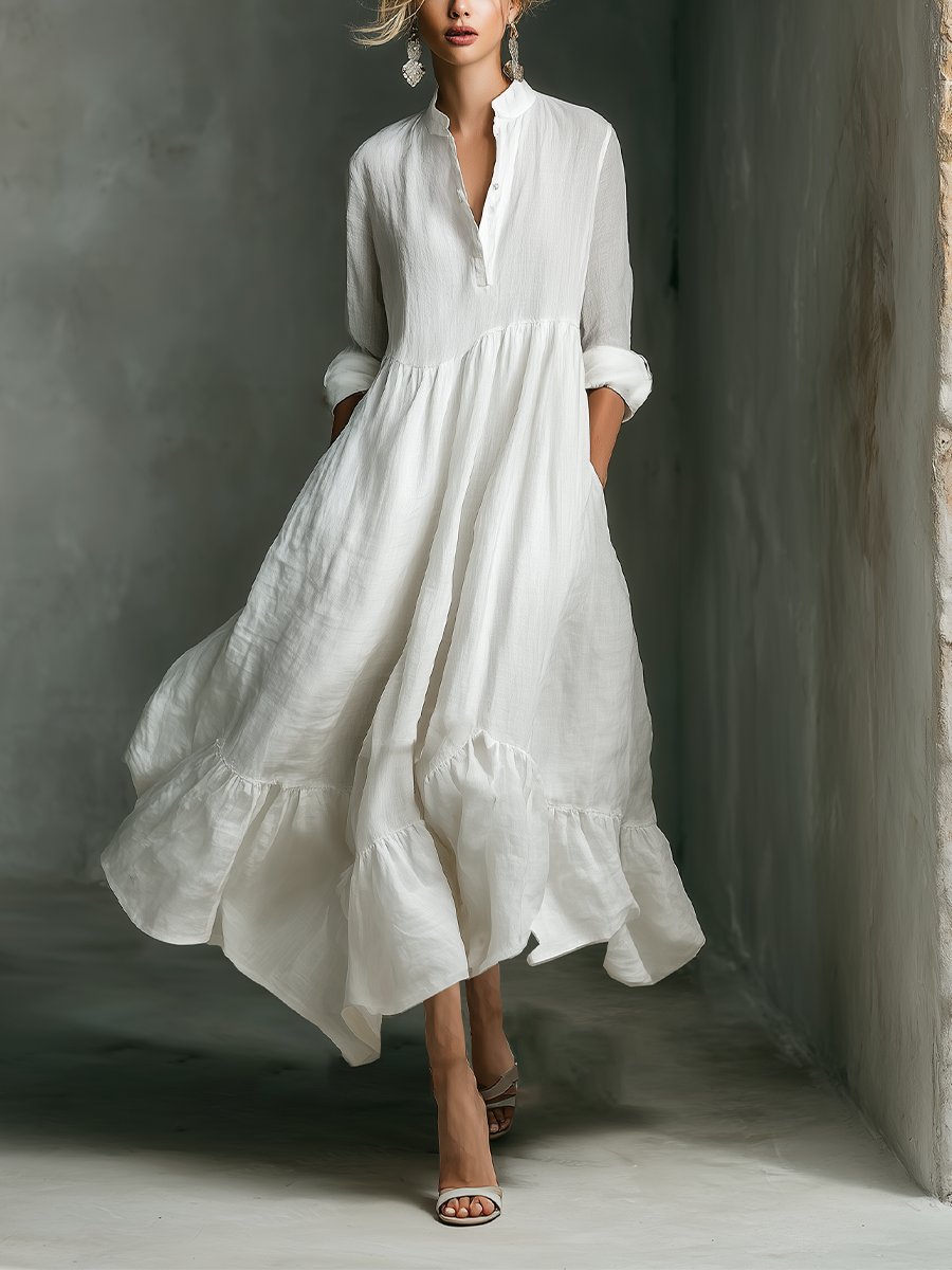 Woman in white long sleeve tiered maxi dress with stand collar. Perfect for casual summer days or elegant vacation wear.