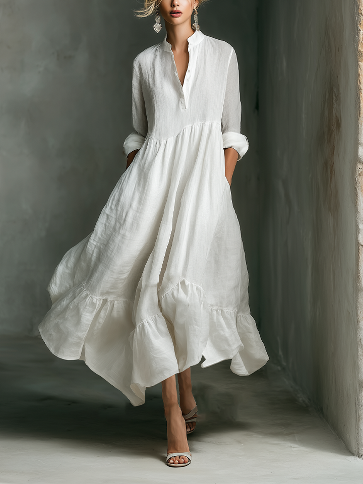 Woman in white long sleeve tiered maxi dress with stand collar. Perfect for casual summer days or elegant vacation wear.