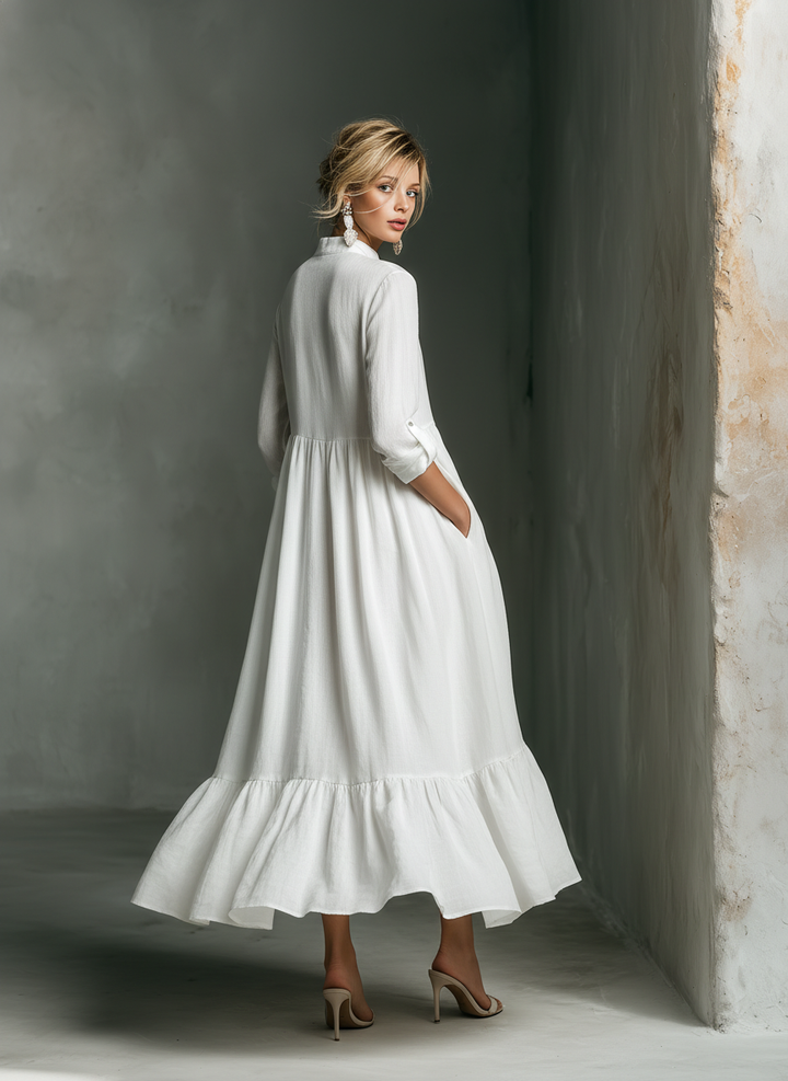 Woman wearing a comfortable white long sleeve tiered maxi dress. Relaxed fit and flowy for casual summer elegance.