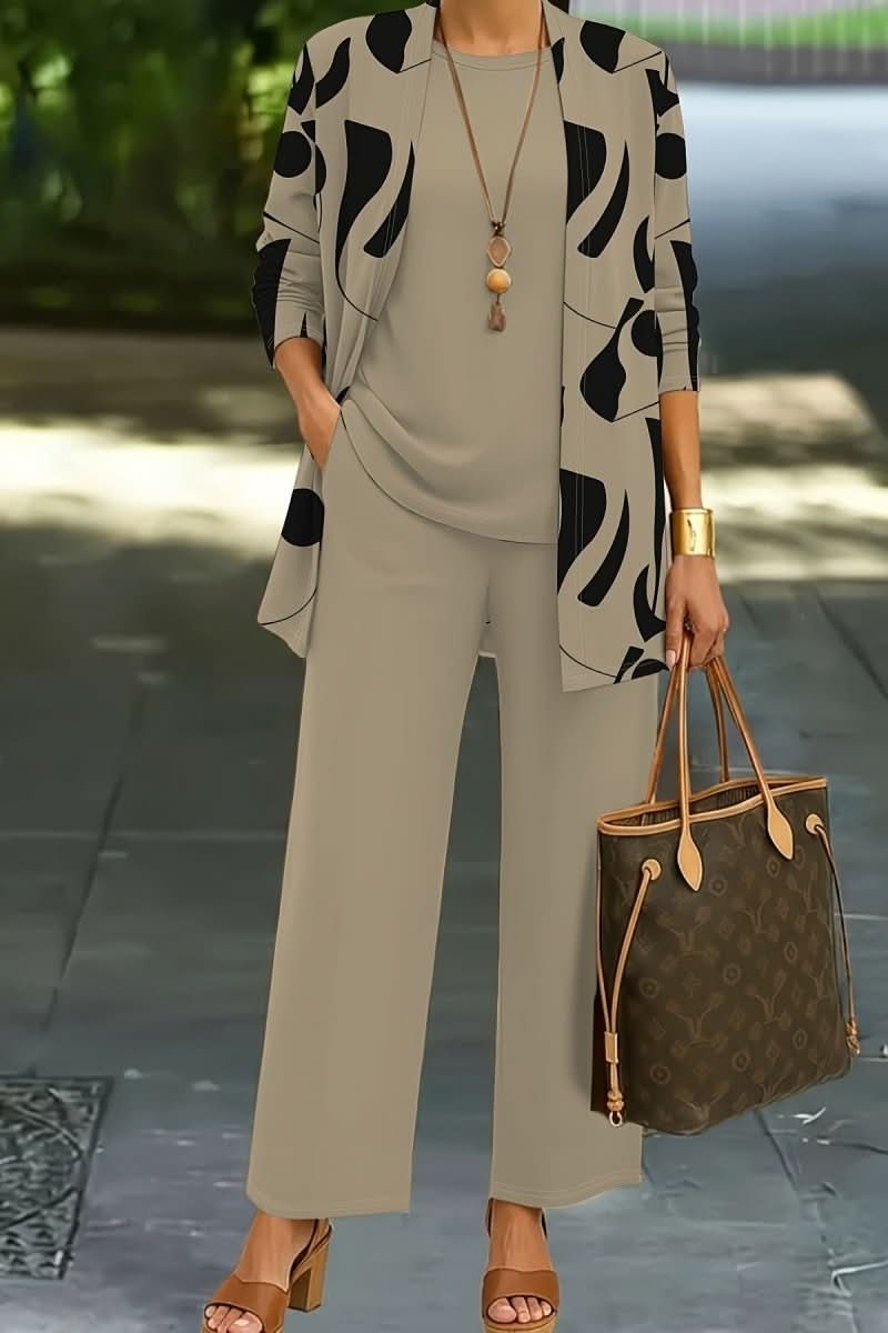 Stylish women's abstract print three-piece outfit. Coordinated set with top, trousers, and jacket.