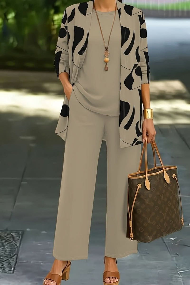 Stylish women's abstract print three-piece outfit. Coordinated set with top, trousers, and jacket.