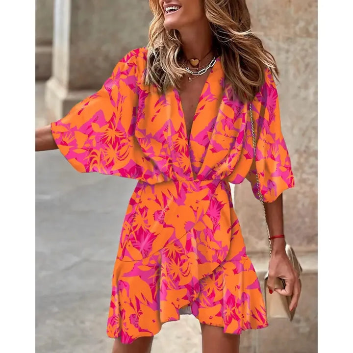 Colorful abstract print women's mini dress featuring V-neck, elbow sleeves, and a flattering ruffle hem.