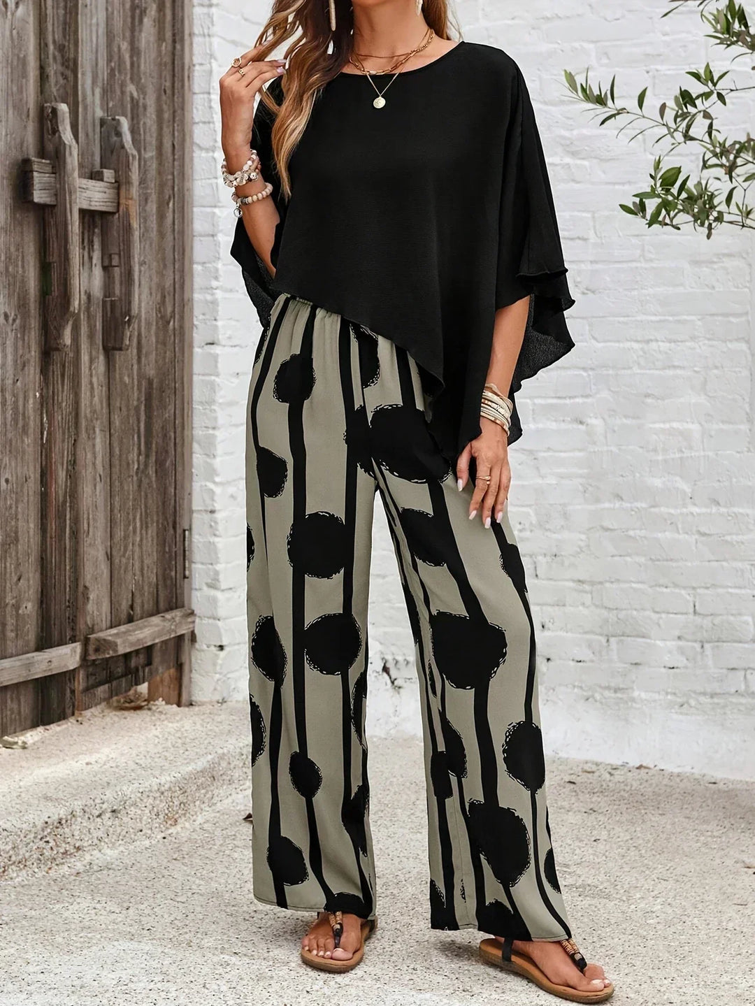Elegant women's outfit: abstract print batwing top with comfortable wide-leg trousers. Casual & chic.