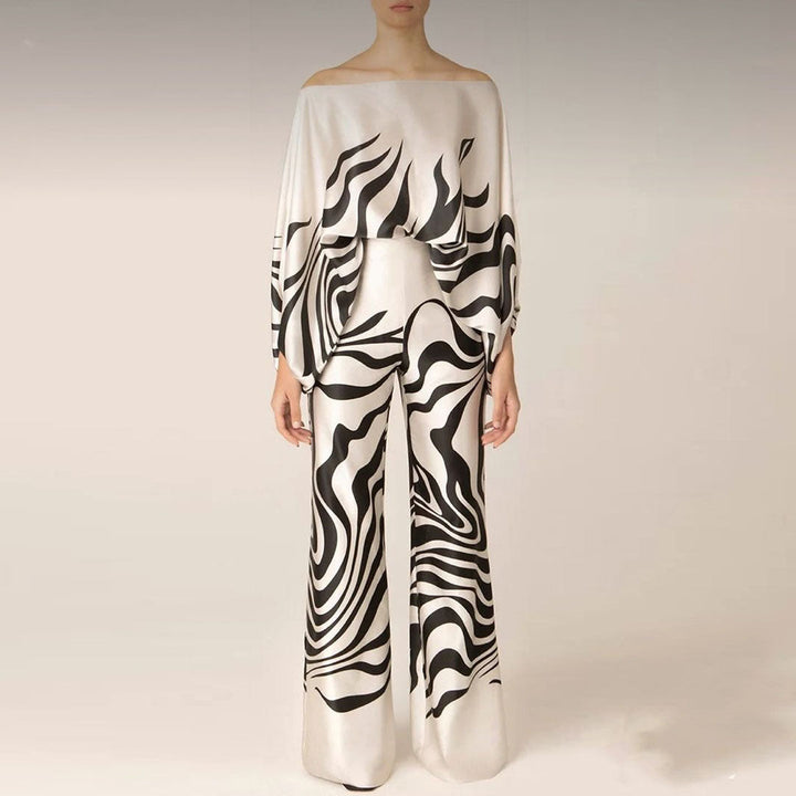 Full length view of a women's artistic printed two-piece set, with a one-shoulder top and elegant wide-leg pants.