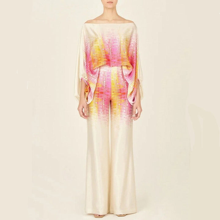 Woman enjoying vacation in an artistic one-shoulder printed two-piece pants set. Comfortable & chic resort wear.