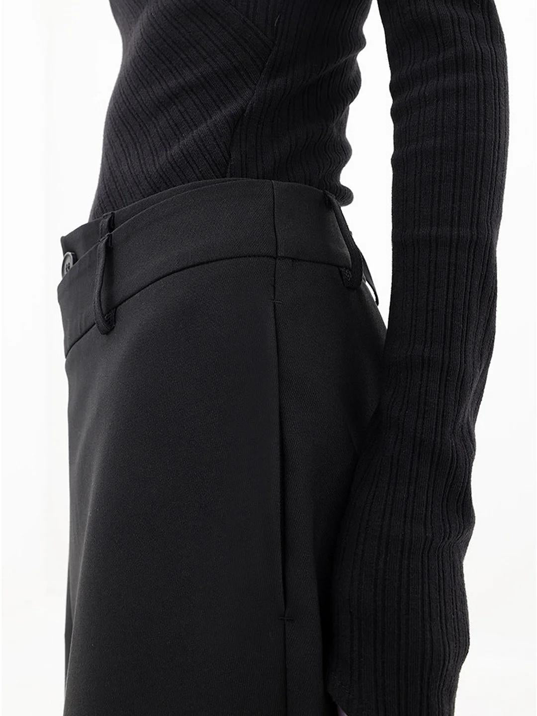 Close-up of asymmetric detail on women's loose fit baggy trousers. Showcasing unique design.