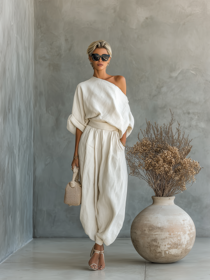 Elegant women's two-piece set featuring an asymmetric drape top and comfortable wide leg pants for resort wear.