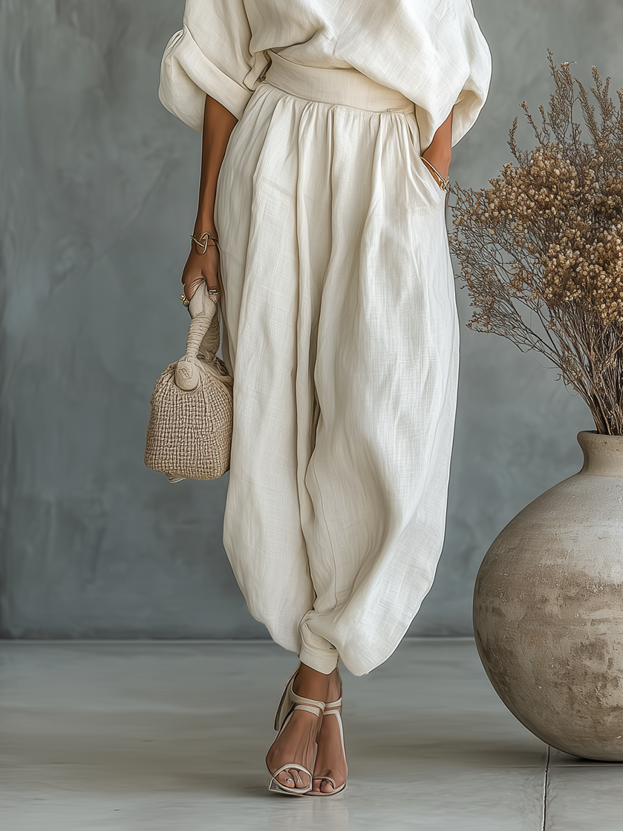Stylish women's minimalist two-piece outfit: asymmetric drape top & wide leg pants with elasticated waist.