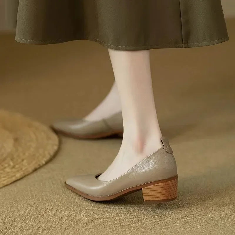 Side view of women's professional beige court shoes with a sharp pointed toe & stable mid block heel.