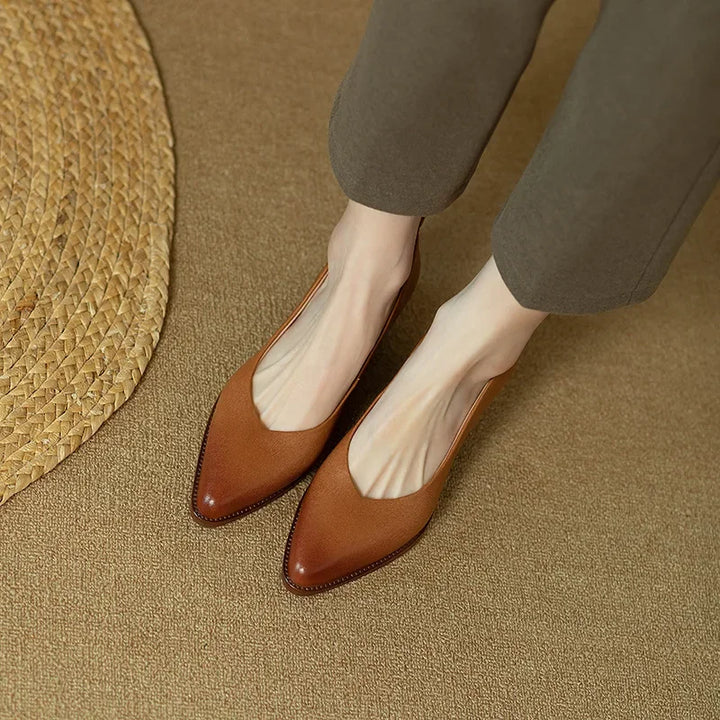 Women's pointed toe slip-on court shoes with mid block heel on foot, demonstrating elegant fit & comfort.