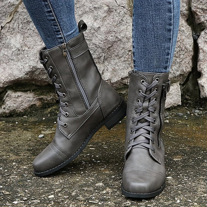 Women's combat boots on a snowy path, showcasing their durability and suitability as winter boots.