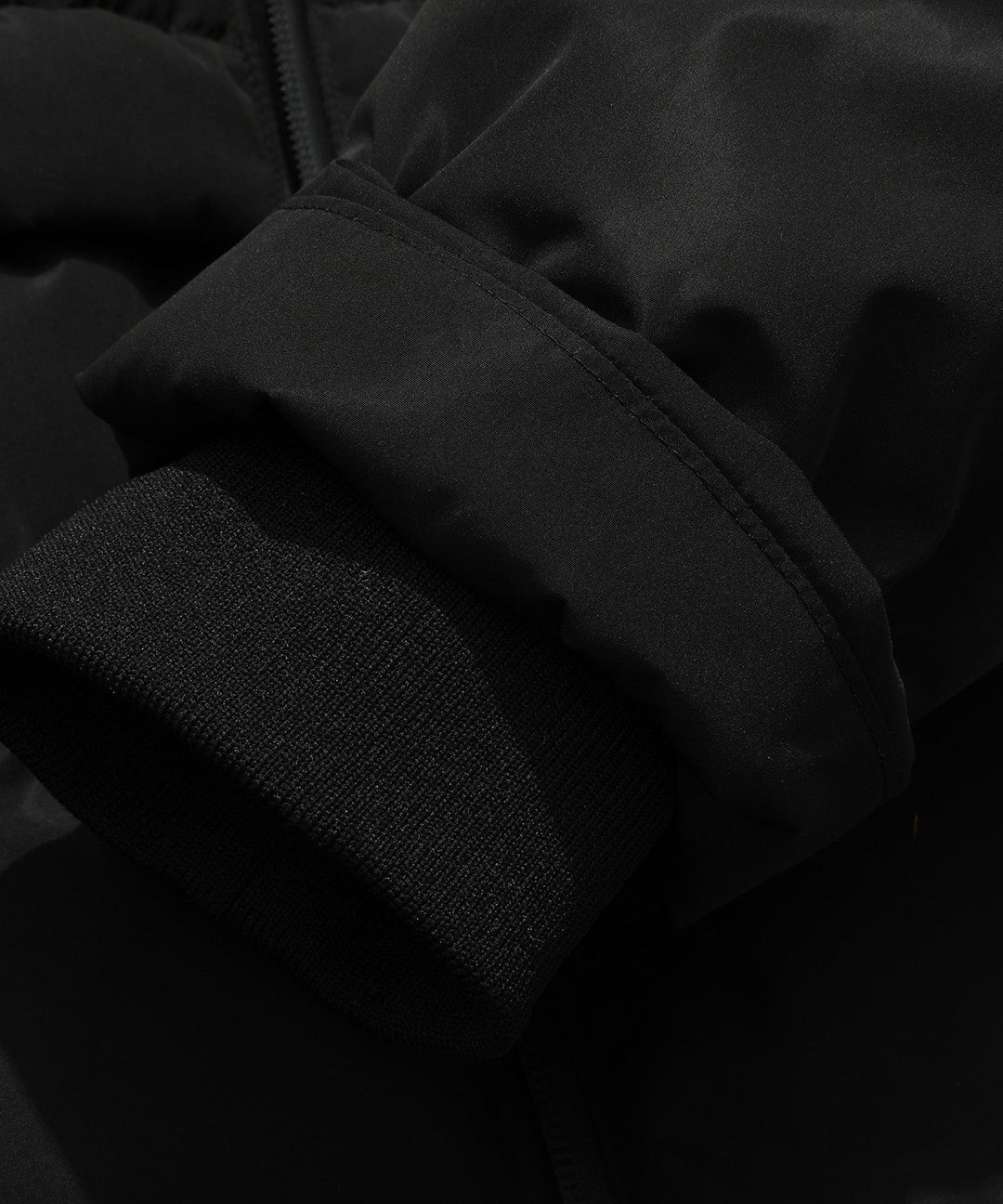 Inside view of pockets and lining of a women's black insulated parka jacket, practical winter wear.