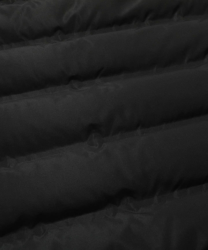 Close-up of the insulated material and stitching on a women's black hooded winter parka coat.