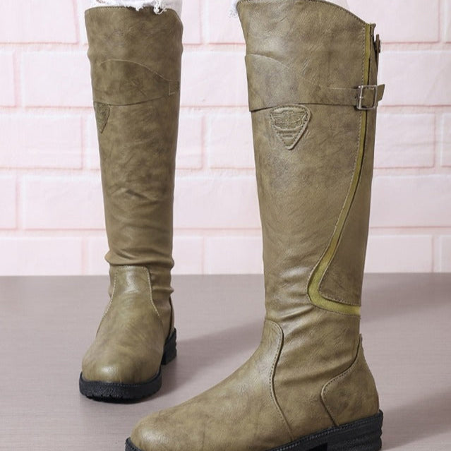 Stylish women's black knee high riding boots with a decorative gold buckle & rugged lug sole for comfort and grip.