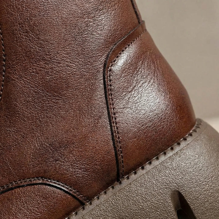 Close-up of women's black lace-up combat boots, showing durable material, platform sole, and arch support.