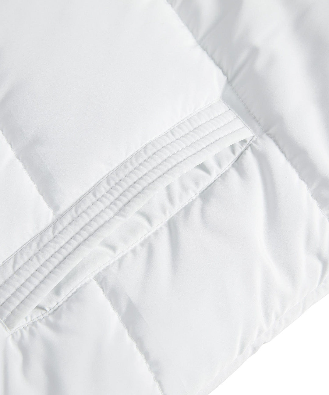 Fashionable women's longline puffer vest with diamond quilting, suitable for outerwear.
