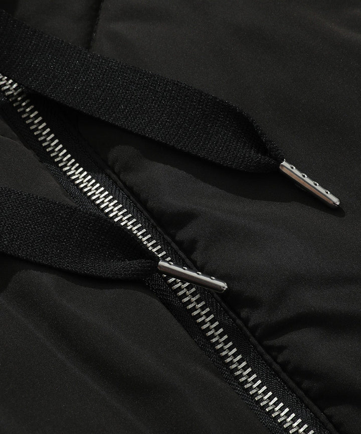 Detail of the zipper and pockets on a women's practical quilted hooded puffer vest