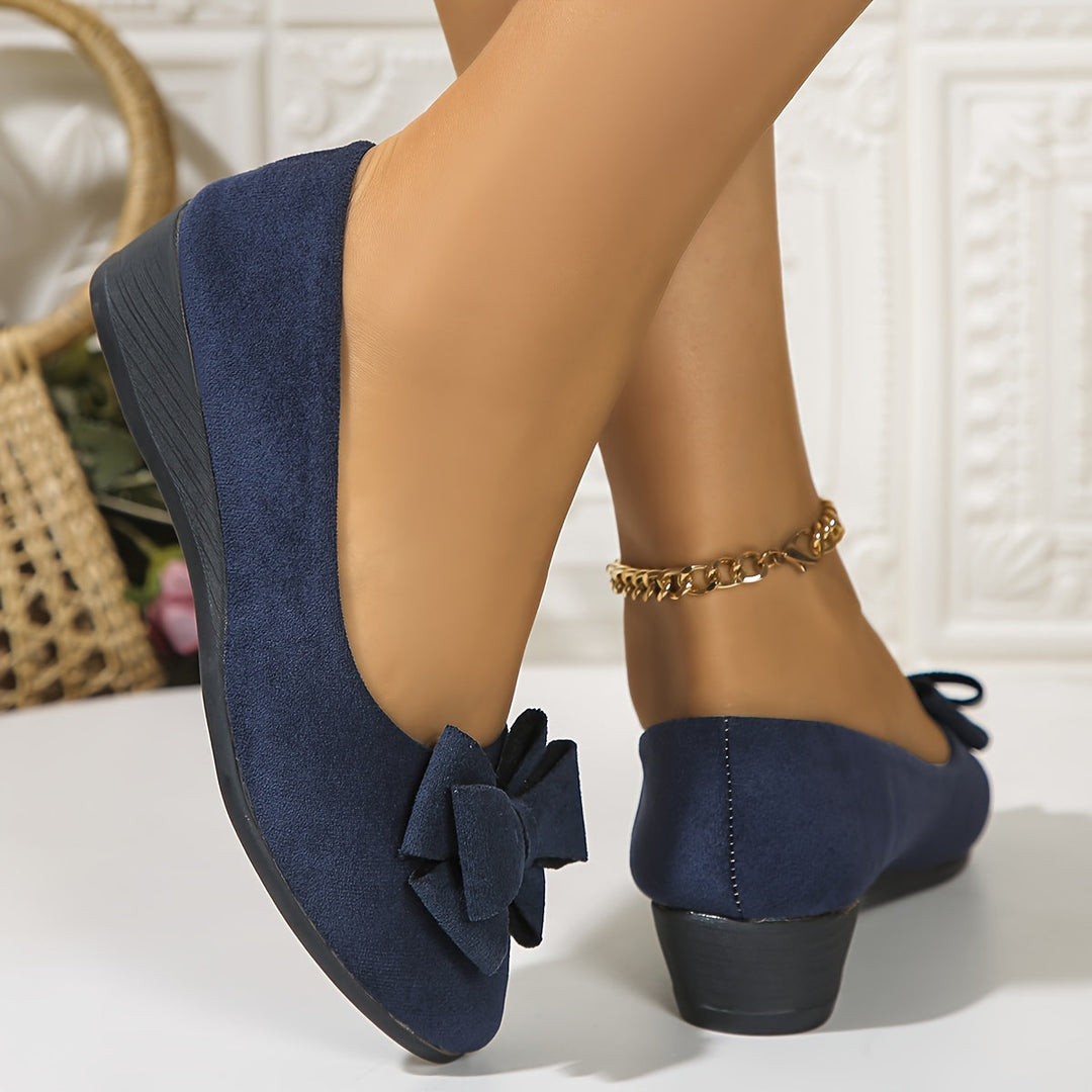 Elegant women's wedge flats with a classic round toe and a delicate bow.