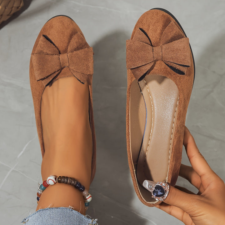 Feminine women's ballet flats with a round toe, slip-on style, and elegant bow.