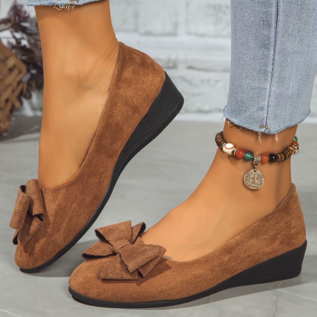 Women's comfortable walking flats, wedge heel, slip-on style, and delicate bow.