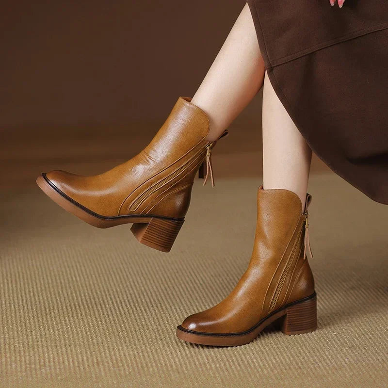 Pair of women's zip-up ankle boots with a block heel, suitable for stylish and comfortable autumn wear.